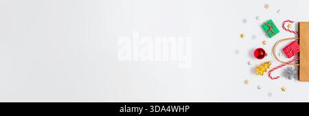 Borsa regalo per le vacanze con regali colorati, caramelle e ornamenti natalizi su sfondo bianco con ampio spazio per gli annunci natalizi e il banner stagionale Foto Stock