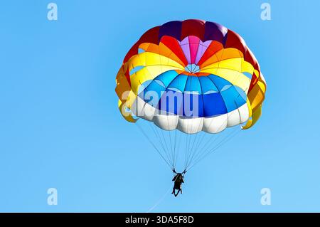 Parapendio con paracadute sullo sfondo del cielo blu. Foto Stock