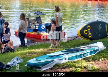 La gente prepara una barca per il surf SUP sul lago in estate: Abakan, Russia - 8 giugno 2024 Foto Stock