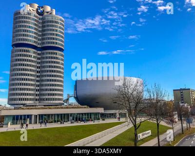 Sede centrale BMW e Museo BMW a Monaco al tramonto, che mostra la torre a quattro cilindri e l'edificio Bowl sotto la calda luce serale. Foto Stock