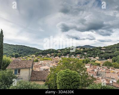 Vista sopraelevata su Collobrieres, un villaggio provenzale a Var, Provenza, con tetti piastrellati annidati tra le colline di Maures sotto spettacolari nuvole. Ospita spr Foto Stock
