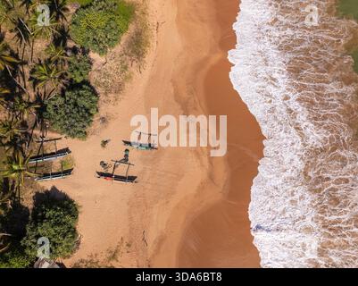 Vista dall'alto verso il basso delle piccole barche da pesca sulla spiaggia di Orange Sand a Kahandamodara, Sri Lanka meridionale Foto Stock