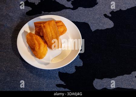 churros fritti su piatto bianco con salsa (tulumbi) Foto Stock