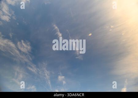 Un cielo sereno e tranquillo pieno di morbide e soffici nuvole, bagnato da un caldo bagliore, ideale per progetti a tema naturale Foto Stock
