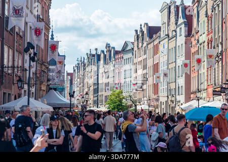 Danzica, Polonia: 2 giugno 2024. Una trafficata Długi strada di Targ (mercato lungo) nella scena di Danzica con una folla di pedoni, tende del mercato all'aperto e un gra Foto Stock