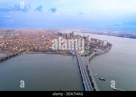 Vista aerea dell'ampio paesaggio urbano che incontra il vasto specchio d'acqua, i ponti che collegano la vivace terra di Lagos, Lagos, Nigeria. Foto Stock