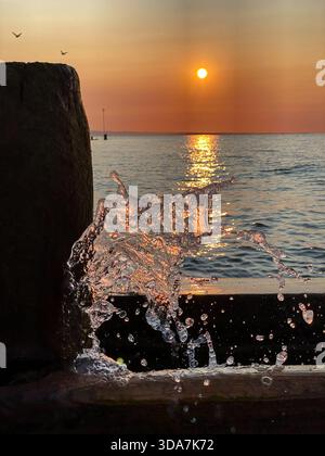 Primo piano, mentre le onde si tuffano su una groyne all'alba sulla spiaggia di worthing Foto Stock