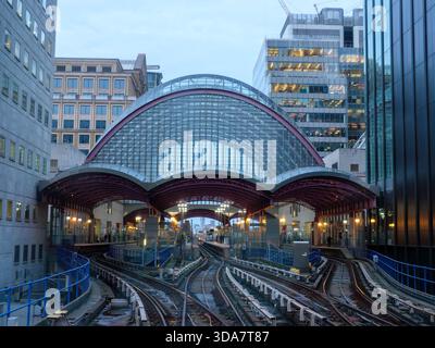 Il treno della Docklands Light Railway si avvicina alla stazione di Canary Wharf, Londra, Regno Unito Foto Stock