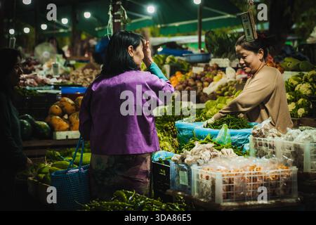 Paro, Bhutan - 17 settembre 2025: Vista di una vivace scena del mercato, dove i prodotti vibranti contrastano con il caldo bagliore delle luci aeree, come locale Foto Stock
