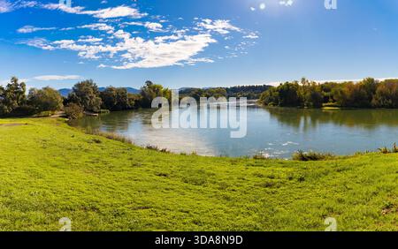 Vista panoramica del villaggio di Miravet e del castello dei Templari che si affaccia sul fiume Ebro in Catalogna, Spagna, con erba verde e cielo blu. Foto Stock