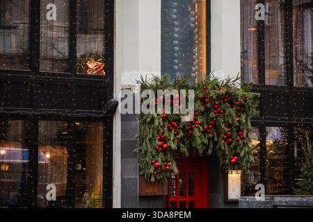Russia. Mosca. 3 dicembre 2025. La finestra del Cafe' e' splendidamente decorata con decorazioni natalizie e ghirlanda con rami di abete e bacche rosse nel centro di Mosca. Foto Stock