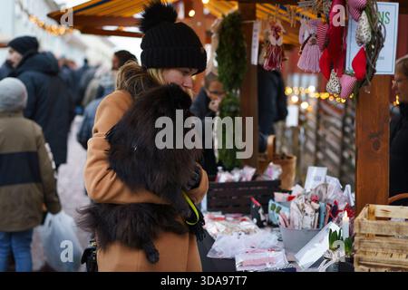 Örebro, Närke - Svezia, 12-09-2025 donna con un cane nero della pomerania al mercatino di natale di Wadköping. Foto Stock