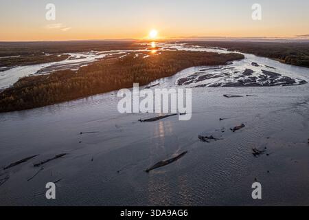 Vista aerea del fiume intrecciato che riflette il bagliore del sole che sorge sulla natura selvaggia dell'Alaska, Salcha, Alaska, Stati Uniti. Foto Stock