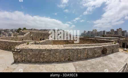 Vista panoramica dell'antica fortezza in pietra con sfondo urbano. Tripoli, Libano. Foto Stock