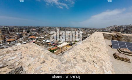 Vista panoramica di un paesaggio urbano da una fortezza in pietra con pannelli solari. Tripoli, Libano. Foto Stock