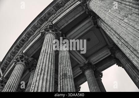 L'immagine monocromatica presenta monumentali colonne corinzie che supportano ornate traballature. La prospettiva ad angolo basso enfatizza la grandezza architettonica e il cl Foto Stock