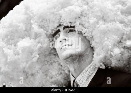 Primo piano in bianco e nero di performer adulti che indossano una nuvola voluminosa, come un capo. L'espressione appare contemplativa, enfatizzando la a teatrale Foto Stock