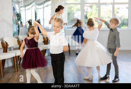 Danze classiche eseguite da bambini preadolescenti in abiti festivi Foto Stock