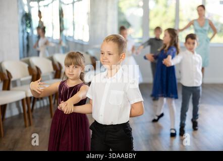 Entusiasti bambini preadolescenti che ballano valzer a coppie nella scuola di danza Foto Stock