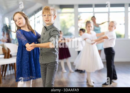 Entusiasti bambini preadolescenti che ballano valzer a coppie nella scuola di danza Foto Stock