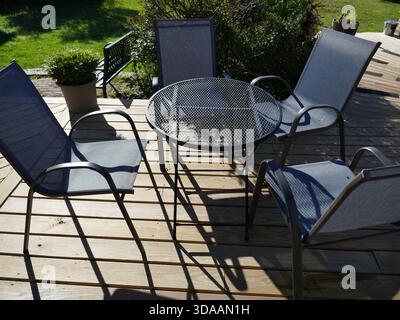 Area pranzo all'aperto del ristorante con mobili in metallo sul patio in legno Foto Stock