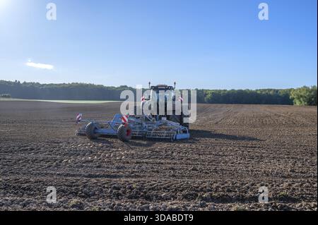 Trattamento sul campo della cooperativa agricola con un trattore di grandi dimensioni con erpice, Othenstorf, Meclemburgo-Pomerania occidentale, Germania Foto Stock