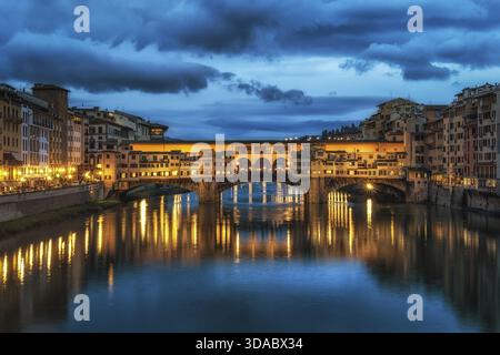 Ponte Vecchio e gli edifici nelle vicinanze di notte che si riflettono sul fiume Arno, Firenze, Italia Foto Stock
