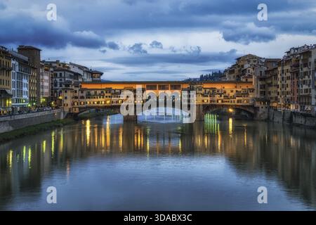 Ponte Vecchio e gli edifici nelle vicinanze di notte che si riflettono sul fiume Arno, Firenze, Italia Foto Stock