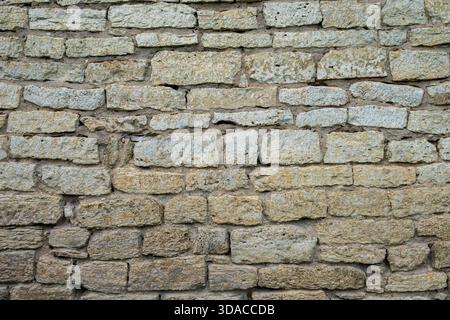 Pareti in mattoni di pietra testurizzata con disposizione dettagliata di pietre di varie dimensioni che creano un aspetto rustico e resistente agli agenti atmosferici. Foto Stock