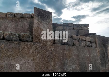 Frammento di un muro fortificato nel Parco Nazionale di Zippori in Galilea, Israele, posto contro un cielo nuvoloso, che mostra murature grezze in pietra e antica architettura difensiva Foto Stock
