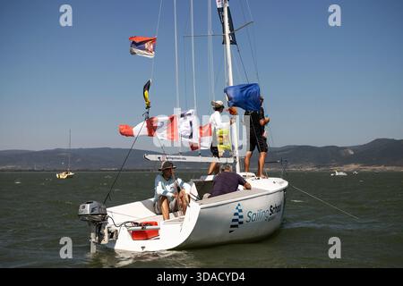 I giudici della barca del comitato di gara monitorano la regata del campionato nazionale Optimist e ILCA 6 sul Danubio vicino a Golubac, in Serbia. Foto Stock