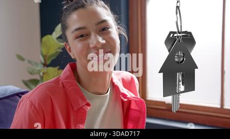 La donna tiene in mano il portachiavi in una moderna camera dal design piatto, che mostra il concetto immobiliare Foto Stock