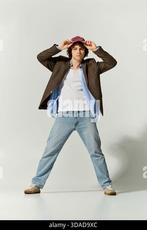Un teenager sicuro indossa abiti eleganti, sfoggiando le tendenze della moda moderna. Foto Stock