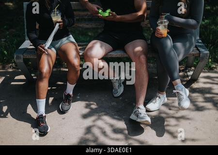 Gruppo di amici che si rilassano su una panchina dopo un allenamento all'aperto Foto Stock