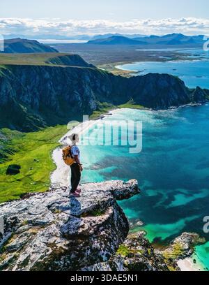 Spettacolari panorami si aprono dal monte Matind, mostrando la splendida costa di Bleik ad Andoya, Norvegia. Il sole proietta un caldo bagliore sulle acque cristalline, invitanti avventure ed esplorazioni. || modello rilasciato Foto Stock
