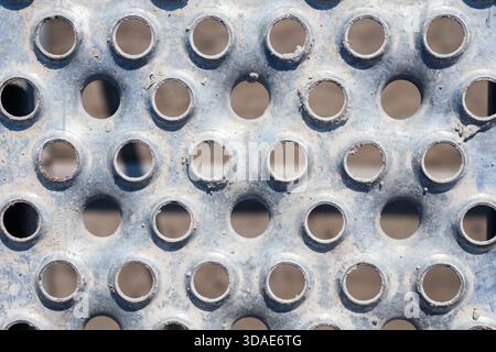 Struttura in acciaio perforato. Vista dall'alto della tavola metallica, della pavimentazione di ponteggi o della passerella. Utilizzato nell'industria edile, nell'architettura e nelle pubbliche relazioni industriali Foto Stock