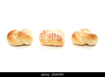 Panini isolati disposti di fila. Panino con tre impasti di pane al forno e lavaggio delle uova. Tradizionale pane svizzero al burro chiamato Zopf o Challah preparato per h Foto Stock