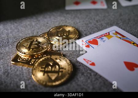 Gettoni bitcoin dorati e carte da gioco che rappresentano gioco d'azzardo, rischio e giochi da casinò online Foto Stock