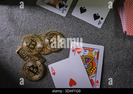 Gettoni bitcoin dorati e carte da gioco che rappresentano gioco d'azzardo, rischio e giochi da casinò online Foto Stock