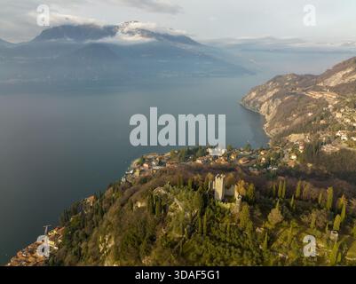 Veduta aerea dell'antico Castello di Vezio sorregge le tranquille acque del Lago di Como, incastonate tra le dolci colline di Varenna, Lombardia, i Foto Stock