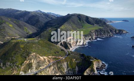 Vista aerea del Bixby Creek Bridge aggrappato alle aspre scogliere che si affacciano sull'oceano turchese, una sinfonia della grandezza della natura, Big Sur, California, Foto Stock