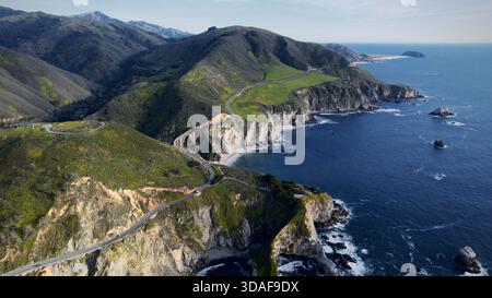 Vista aerea del tortuoso ponte Bixby Creek aggrappato alla costa frastagliata, dove le colline verdeggianti incontrano il profondo blu del Pacifico, Big Sur, Californi Foto Stock