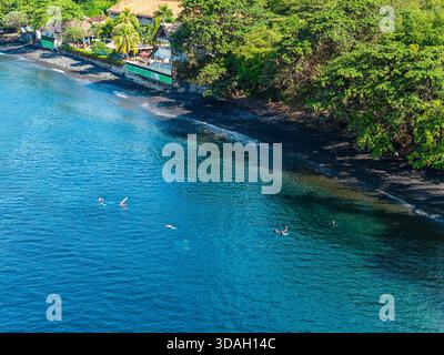 Vista aerea con droni di subacquei e snorkelling nelle acque cristalline di Tulamben, Bali Foto Stock