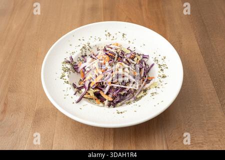 Un'insalata verde con frutta, dove la lattuga Batavia viene combinata con mela ​​green affettata a fette sottili, uva verde tagliata a metà e un condimento fresco alla menta e al lime Foto Stock
