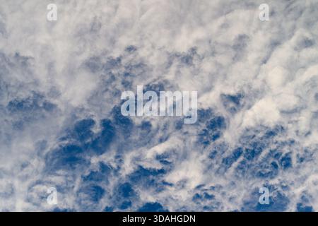 Cielo nuvoloso spettacolare con formazioni uniche e ricche tonalità blu, ideale per progetti legati alla natura. Foto Stock