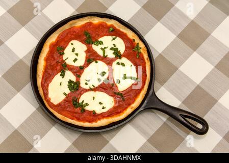 Pizza Margherita in una padella di ghisa Foto Stock