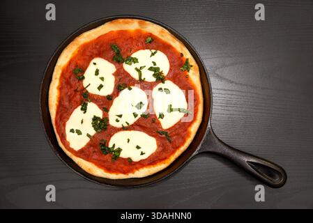 Pizza Margherita in una padella di ghisa Foto Stock