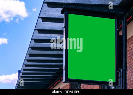 Cartellone verde vuoto sulla strada della città. Poster con schermo verde sulla strada. Spazio vuoto per il testo. Foto Stock