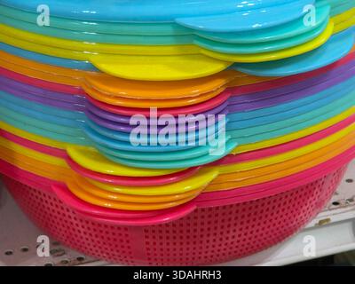 Sfondo astratto vivace e colorato di una pila di cestelli in plastica per creare un motivo arcobaleno. Questa allegra vista ravvicinata mostra più colori luminosi A. Foto Stock