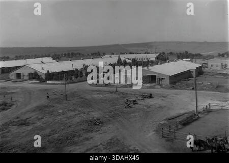 Bohorodychne, regione di Donetsk, RSS Ucraina, anni 1970 Una vista panoramica archivistica di un grande complesso agrituristico situato in una valle vicino alle colline. Lunghe stalle in mattoni e stalle con tetti in ardesia sono disposte intorno a cortili di sterrato. In primo piano, i cavalli sono visti in coralli di legno, mentre i materiali da costruzione suggeriscono lo sviluppo continuo delle infrastrutture rurali. Questo paesaggio cattura le dimensioni dell'allevamento e l'atmosfera tranquilla della campagna sovietica nel Donbas. Foto Stock
